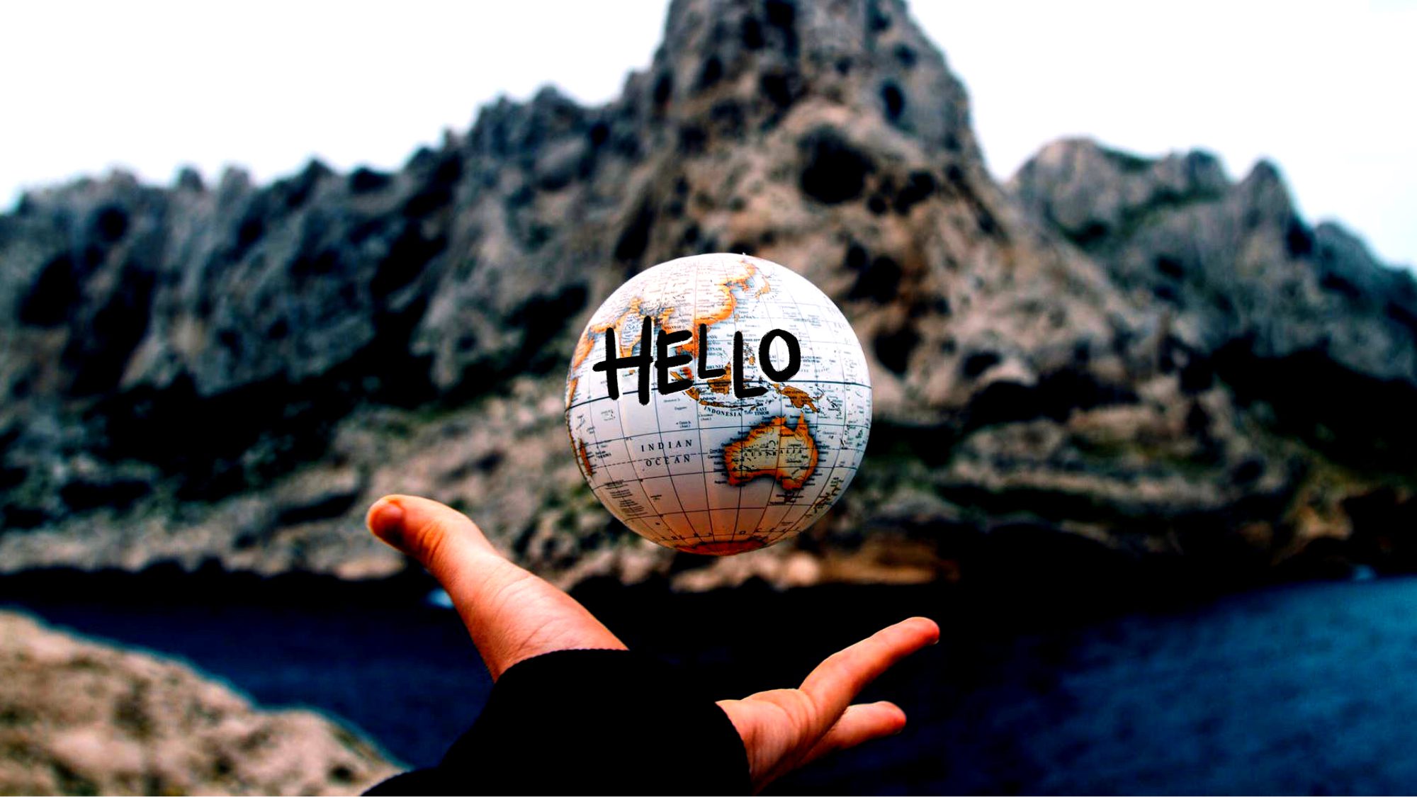 Holding globe with hello text and moutain background