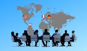 conference in foreground, map in background with USA, Germany, Argentinia, and French flags marked on map